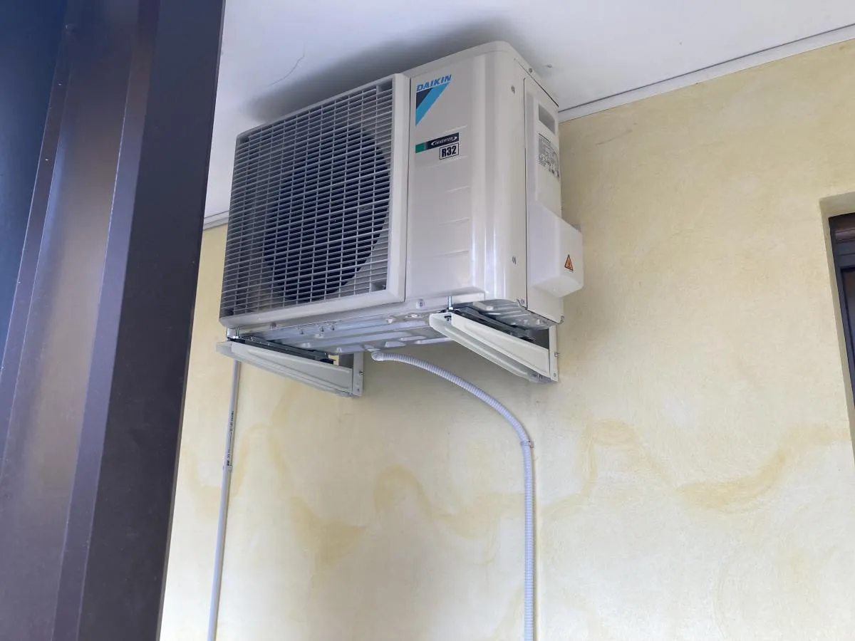 Unità esterna di un climatizzatore installata su staffe a Magenta